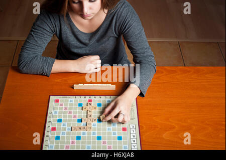 Jeune brunette adolescentes jouant au Scrabble Banque D'Images