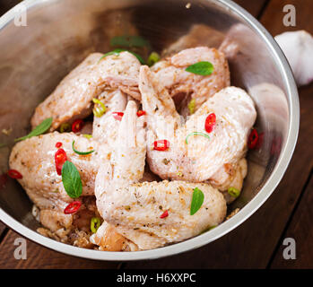 Ailes de poulet cru mariné préparé dans un style asiatique avec le miel, l'ail, la sauce de soja et les herbes Banque D'Images