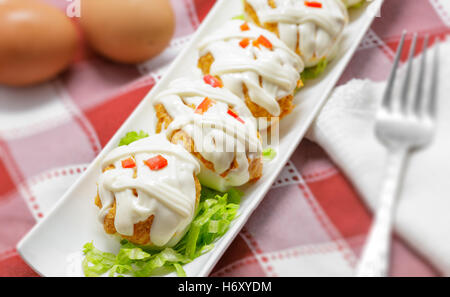 Oeufs farcis au thon, tomates, la mayonnaise et le poivre rouge sur fond blanc Banque D'Images