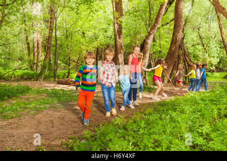 Happy kids walking holding hands in park Banque D'Images