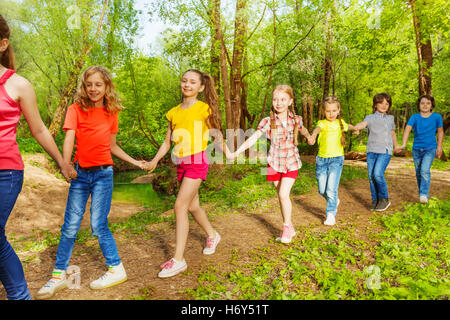 Heureux les enfants marcher dans la forêt holding hands Banque D'Images