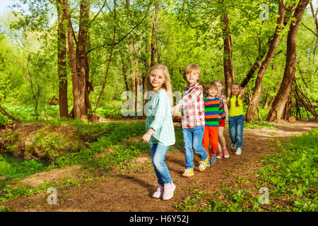 Les enfants marcher dans la forêt d'été holding hands Banque D'Images