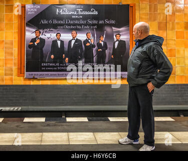 Hauts homme regarde Madame Tussaud's ad James Bond à Rosenthalerplatz U-bahn gare, Mitte, Berlin Banque D'Images
