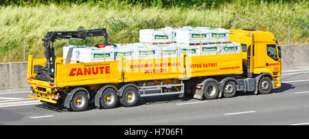 La logistique de transport des matériaux de construction Canute hors charge grue camion remorque articulé poids lourds transportant des 'Tarmac' 'Durox' bloque le long de l'autoroute britannique Banque D'Images