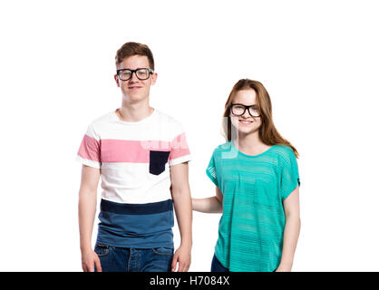 Teenage boy and girl wearing eyeglasses. Studio shot, isolé. Banque D'Images