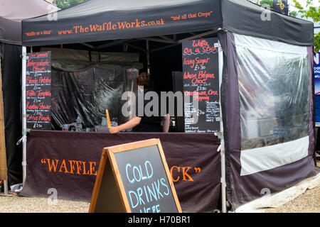 Les visiteurs de la saucisse et de la bière annuelle Music Festival à pied le long des avenues de stands de nourriture de rue, Jimmy's Farm, Ipswich, Royaume-Uni Banque D'Images