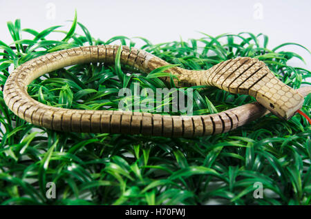 King Cobra snake jouet en bois fabriqués à partir de plastique sur l'herbe Banque D'Images