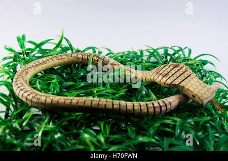 King Cobra snake jouet en bois fabriqués à partir de plastique sur l'herbe Banque D'Images