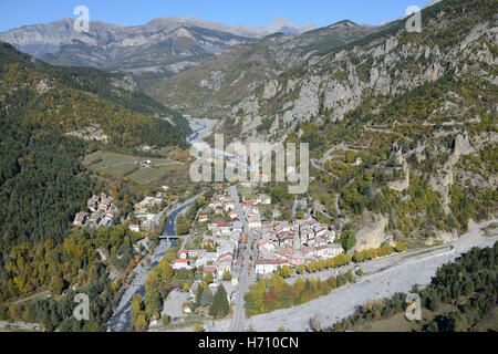 VUE AÉRIENNE. Village médiéval entouré de couleurs automnales dans la haute vallée du Var. Guillaumes, Alpes-Maritimes, France. Banque D'Images