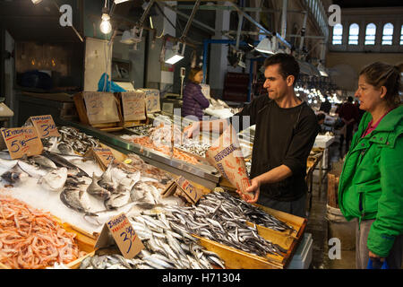 Un poissonnier prend une commande pour squid à partir d'un client dans le marché central d'Athènes Banque D'Images