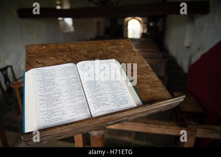 Une bible ouverte sur le pupitre à l'intérieur de la cité médiévale du 13e siècle, église St Tanwg situé dans les dunes de sable près de la plage à Llandanwg, Snowdonia, Gwynedd,. Pays de Galles UK Banque D'Images