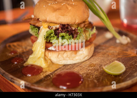 Libre de frais maison magnifiquement servi burger isolé sur une planche à découper en bois Banque D'Images