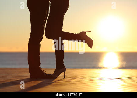 Deux jambes serrant dans l'amour sur la plage Banque D'Images