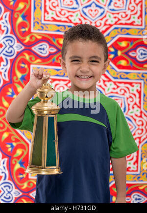 Adorable Smiling Young Boy with Vintage lanterne sur tissu de fête Ramadan Banque D'Images