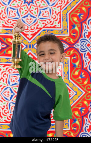 Smiling Young Boy with Vintage lanterne sur tissu de fête Ramadan Banque D'Images