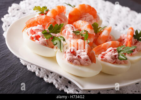 Maison de vacances apéritif : oeufs farcis aux crevettes et fromage à la crème sur une assiette sur la table. Banque D'Images