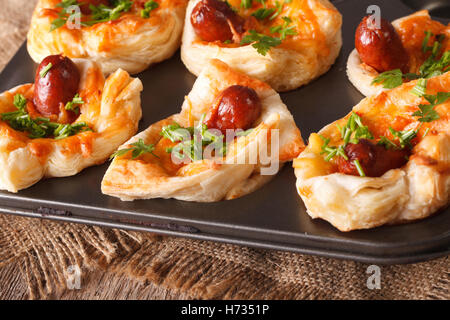 Des muffins fraîchement cuits avec de la saucisse, du fromage et l'oignon close up dans le plat de cuisson horizontale. Banque D'Images