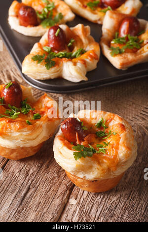 Des muffins fraîchement cuits avec de la saucisse, du fromage et l'oignon sur la table. La verticale Banque D'Images