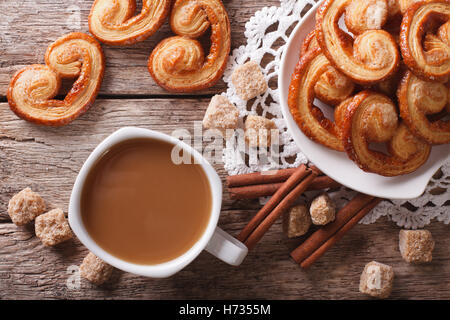 Café avec du lait et des biscuits Palmiers close-up sur la table horizontale vue du dessus. Banque D'Images