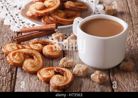 Café avec du lait et des biscuits Palmiers close-up sur la table horizontale. Banque D'Images