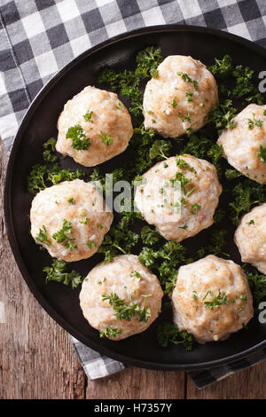 Boulettes de viande à la vapeur avec du persil sur la plaque sur la table. vertical Vue de dessus Banque D'Images