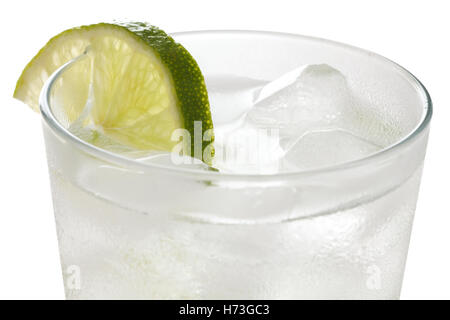 Détail d'un simple verre d'eau avec des cubes de glace flottante et lime slice Banque D'Images