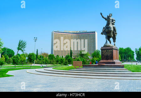 La statue d'Amir Timur, entourée d'un magnifique parc verdoyant et avec l'Hôtel Ouzbékistan en arrière-plan, Tachkent, Ouzbékistan Banque D'Images