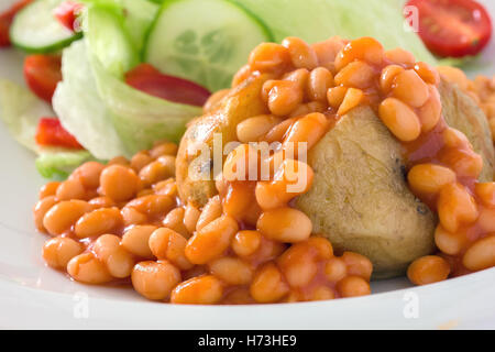 Détail d'une pomme de terre avec des haricots à la veste et une salade hors foyer. Banque D'Images