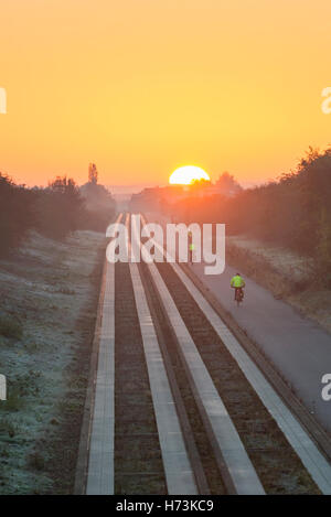 Plus de Cambridgeshire, Royaume-Uni, 2 novembre 2016. Cyclistes roulent vers Cambridge comme le soleil se lève sur les pistes d'un clair et net, frosty matin d'automne. L'air clair et première gelée d'automne dans l'Est de l'UK jeter une lumière dorée sur le trajet du matin. Julian crédit Eales/Alamy Live News Banque D'Images