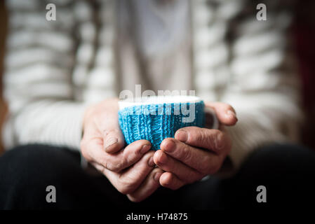 Femme âgée holding tasse de café chaud ou un thé Banque D'Images