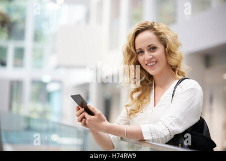 Jeune femme aux cheveux blonds smartphone utilise à l'intérieur moderne Banque D'Images