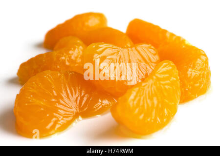 Groupe de segments de mandarines dans un sirop léger sur blanc. Banque D'Images