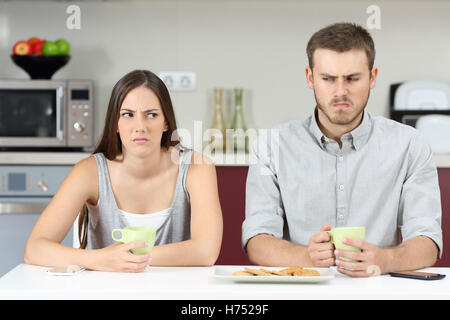 Vue frontale d'un angry couple à côté de l'autre argument après dans la cuisine pendant le petit déjeuner à la maison Banque D'Images