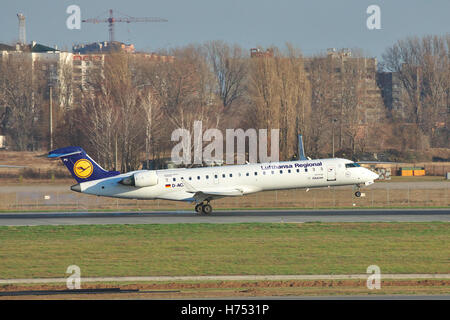 Borispol, l'Ukraine - 13 novembre 2010 : Lufthansa Canadair CL-600 de jets régionaux CRJ-701ER C'est l'atterrissage sur la piste avec quelques construire Banque D'Images