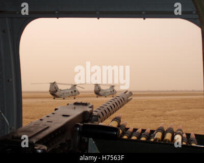 19 octobre 2003 un pistolet à machine lourd monté sur un hélicoptère CH-46 Sea Knight, en taxi pour le décollage avec d'autres Sea Knights à l'aéroport de Basra. Banque D'Images