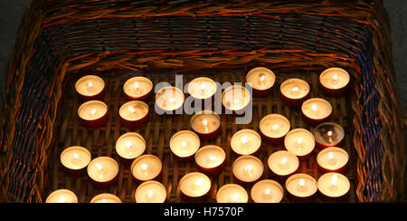 De nombreuses bougies allumées dans le panier en osier au cours de la célébration religieuse Banque D'Images