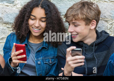 Mixed Race African American girl, interracial adolescents garçons et filles, hommes et femmes, les sms et l'utilisation mobile cell phone Banque D'Images