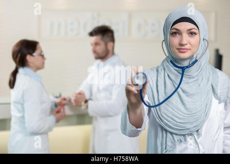 Vue de face d'une femme médecin arabe montrant stéthoscope. Banque D'Images