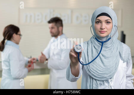 Vue de face d'une femme médecin arabe montrant stéthoscope. Banque D'Images