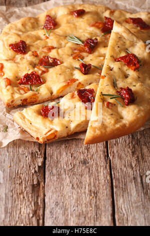 Des tranches de pain focaccia italienne aux tomates séchées et romarin fermer vers le haut sur la table. vertical Banque D'Images