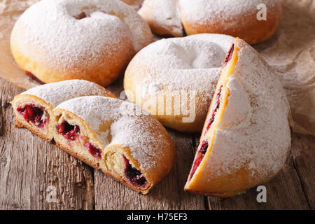 Tranches de bun ensaimadas avec berry et remplissage du sucre en poudre sur la table horizontale. Banque D'Images