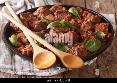 De délicieux plats grecs : boeuf avec sauce stifado et basilic close up dans un plat sur la table horizontale. Banque D'Images