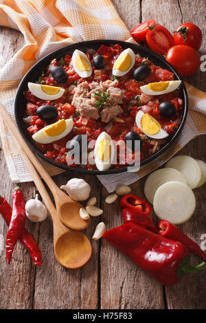 Salade de thon tunisien avec légumes grillés et les ingrédients sur la table close-up vertical. Banque D'Images