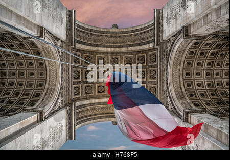 Low angle view of Arc de Triomphe avec drapeau français, Paris, France Banque D'Images