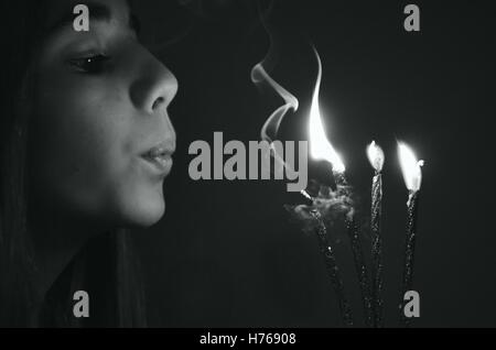 Girl blowing out candles sur un gâteau d'anniversaire Banque D'Images
