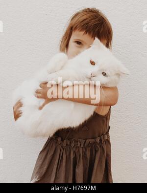 Fille de câliner son chat avec des yeux de couleurs différentes Banque D'Images