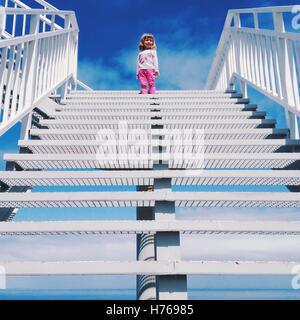 Fille en haut d'un escalier Banque D'Images