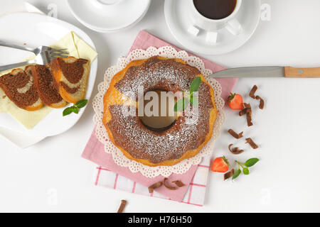 En gâteau bundt et tasse de café sur fond blanc Banque D'Images