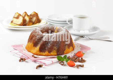 En gâteau bundt et tasse de café sur fond blanc Banque D'Images