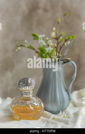 Flacon de parfum ancien avec un pichet rempli de fleur de printemps Banque D'Images